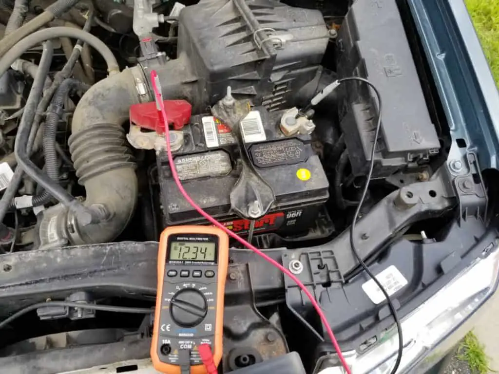 multimeter showing the volts of a car battery from terminal to terminal