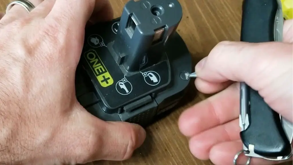 Image showing how to remove the anti-tamper plug that hides a final screw on the battery.  Removing this plug will void any warranty.