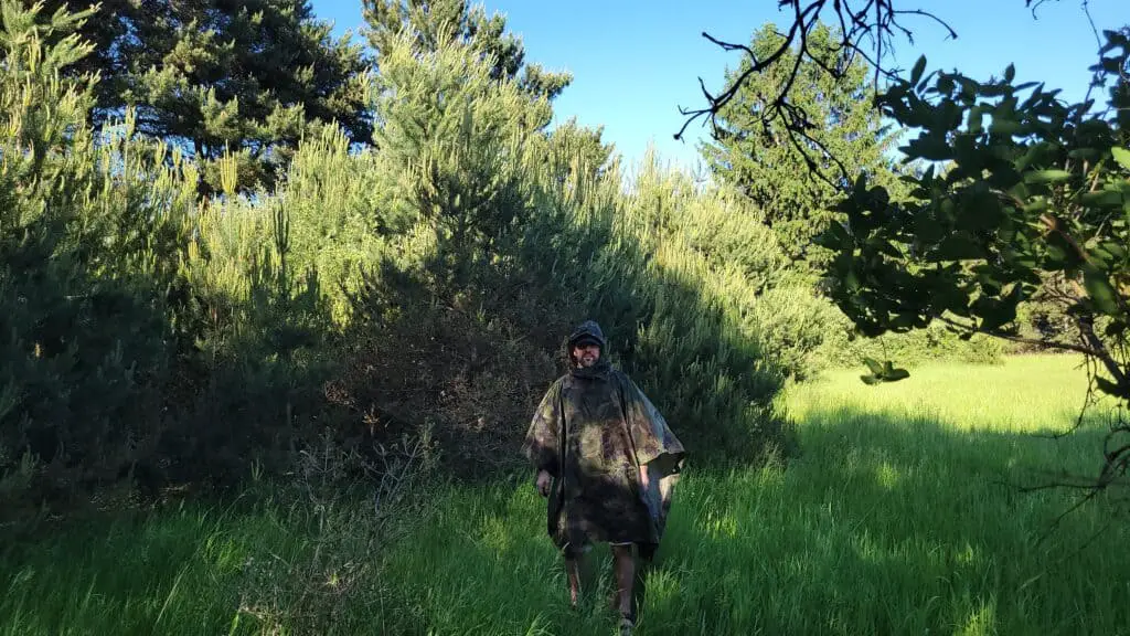 Author wearing Angolan Military Surplus Poncho against a pine tree background.