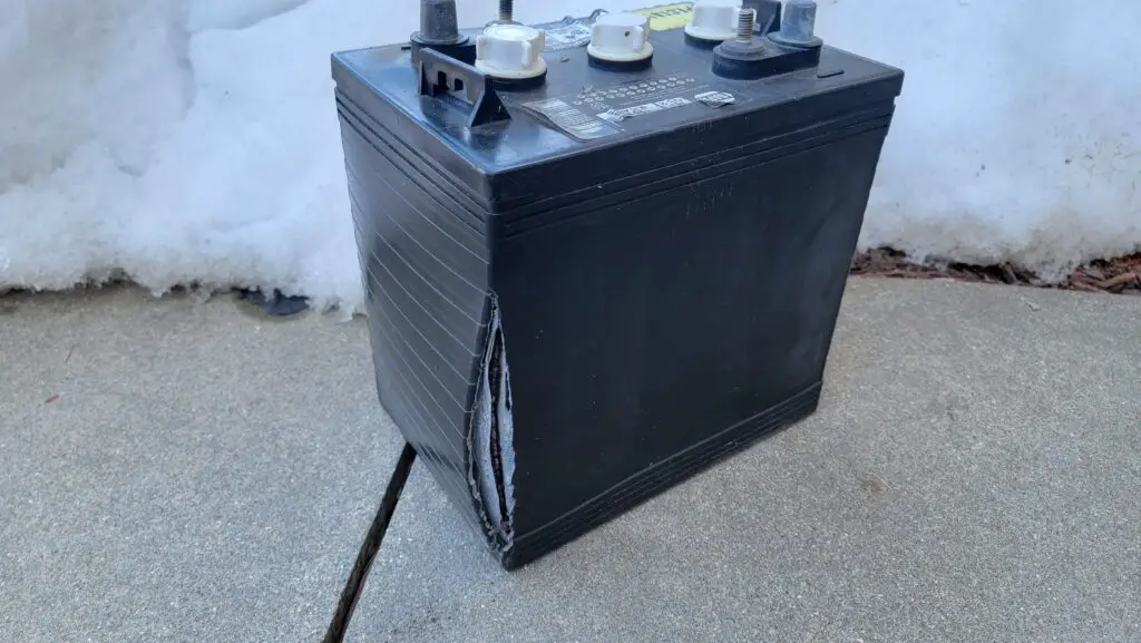 Frozen battery.  Image showing the cracked casing of a 12-volt battery that was left outside in freezing conditions with a low state of charge. 