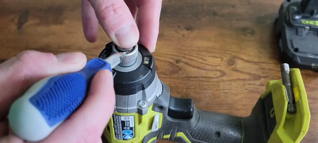 image showing how to pry the retaining clip off a ryobi impact driver